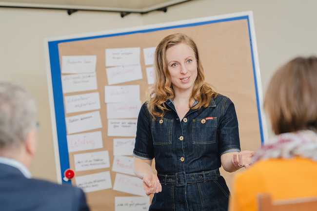 Moderatorin interagiert mit der Gruppe im Workshop