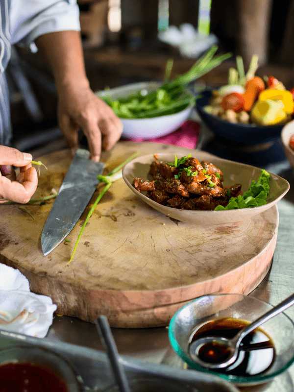 Runde Holzplatte, auf der Kräuter für Gericht geschnitten werden