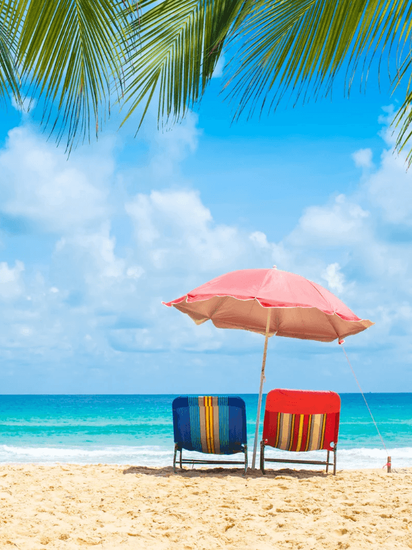 Zwei Strandsessel und ein Sonnenschirm am Strand