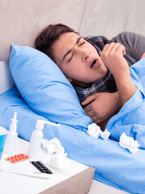 Kranke Person, die mit einer Erkältung im Bett liegt und hustet